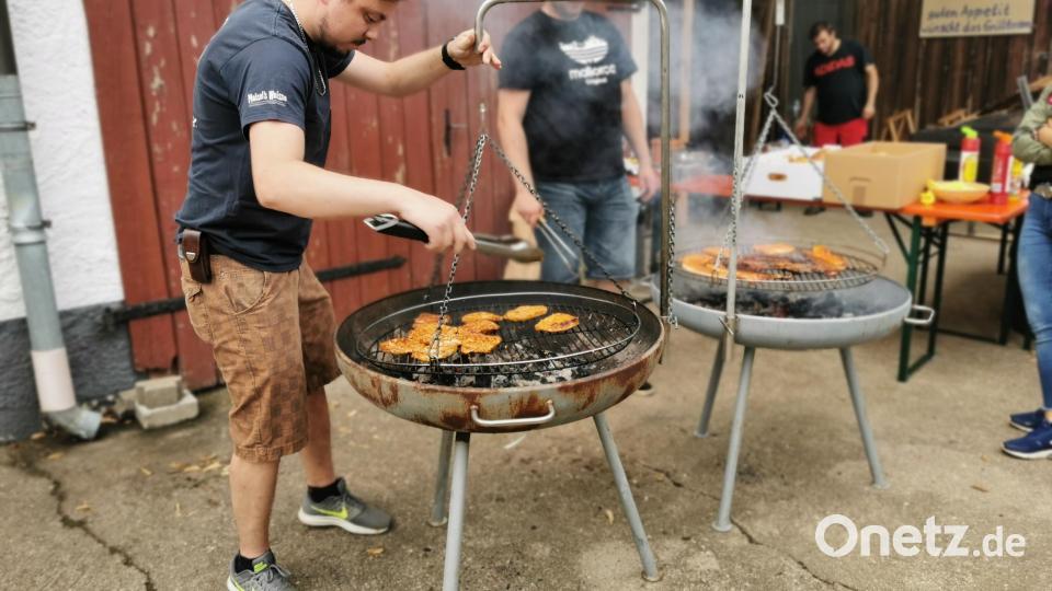 Auf zwei Grillpfannen werden Bratwürste und Steaks zubereitet. Bild: hzi