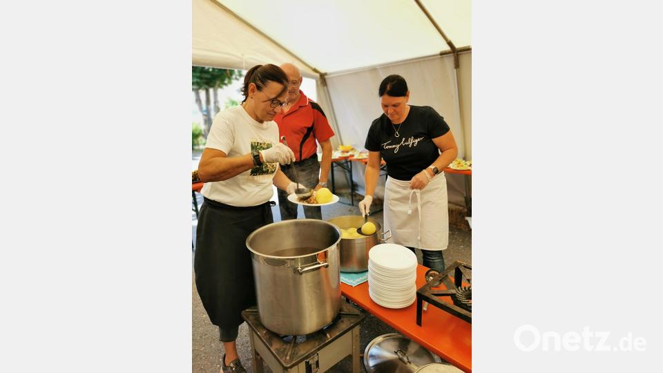 Der frisch zubereitete Schweinebraten wird von zahlreichen Helfern im „Servicezelt“ an die Besucher ausgegeben. Bild: hzi