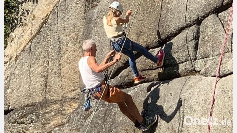 Jugendbetreuer Michael Schornbaum vom Deutschen Alpenverein Tirschenreuth hilft dem Mädchen beim Abseilen am Neuhauser Burgfelsen. Bild: Wolf/exb