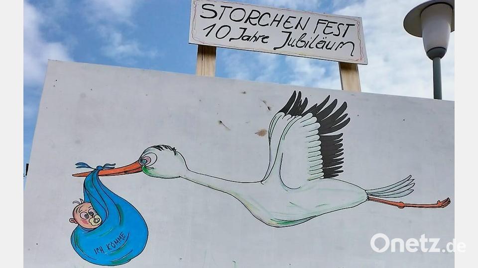 Die Storchenbilder sollen den Kinderreichtum im Dorf seit dem Einfall der zwanzig Störche humorvoll demonstrieren. Gemalt hat die Karikaturen Künstler Tom Brankovic (rechts neben Traktorfahrer Hans Reisnecker). Bild: ubb