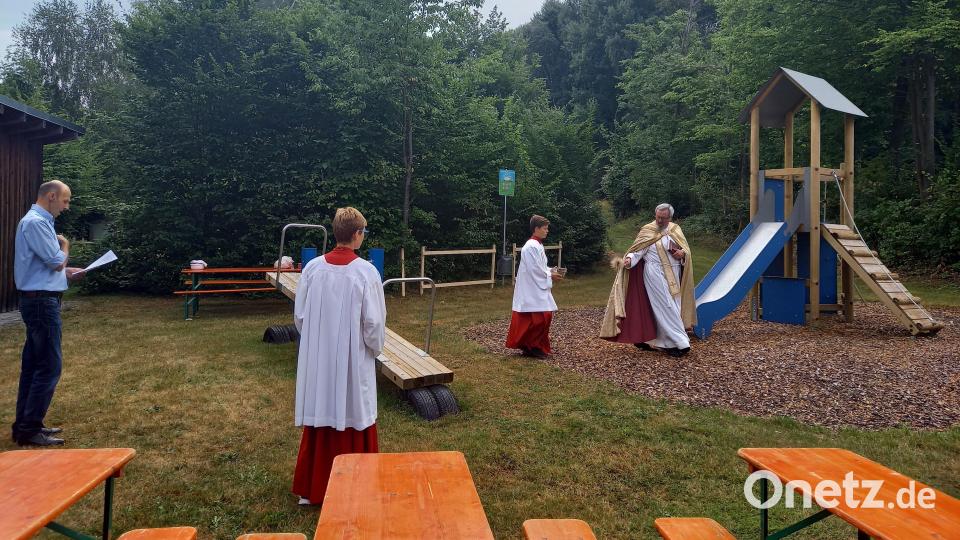 Pfarrer Markus Ertl segnet den neuen Spielplatz am Pfarrheim in Glaubendorf. Bild: Anita Kiener/exb