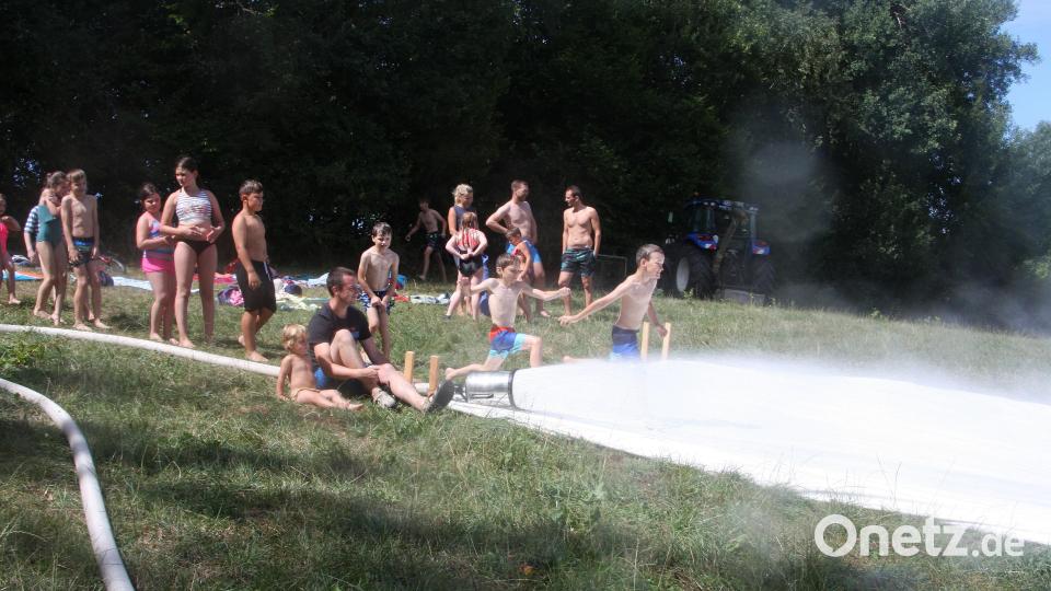 Die Wasserrutsche der Feuerwehr Falkenberg lockte viele Kinder und Jugendliche sowie auch einige Erwachsene an den Hang nahe der Waldnaab. Bild: wro