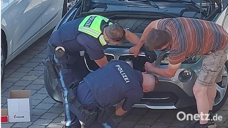 Mitarbeiter der Weidener Polizei versuchen, den fedrigen Fahrgast zu befreien. Bild: Polizei Weiden/exb