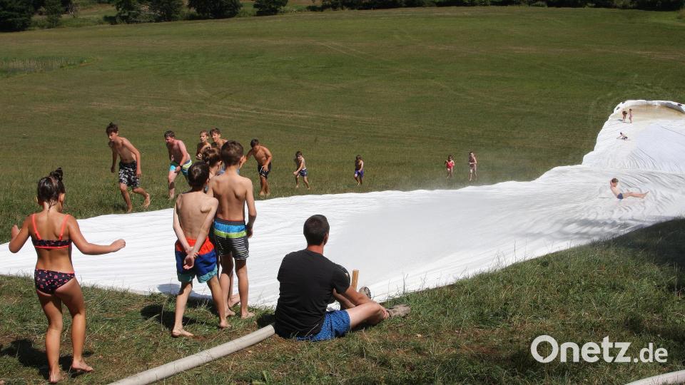 Die Wasserrutsche der Feuerwehr Falkenberg lockte viele Kinder und Jugendliche sowie auch einige Erwachsene an den Hang nahe der Waldnaab. Bild: wro