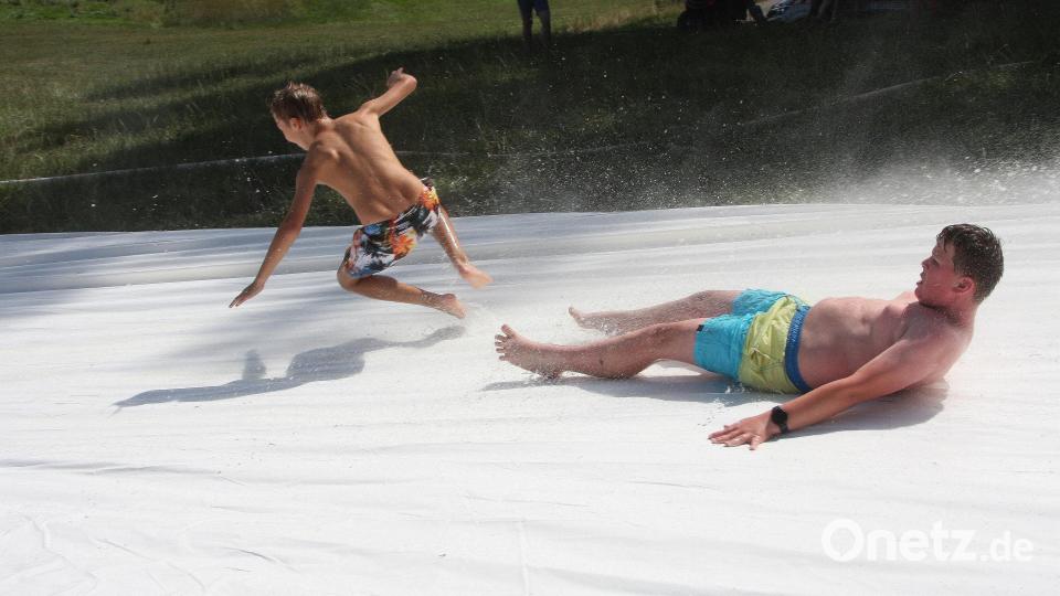 Die Wasserrutsche der Feuerwehr Falkenberg lockte viele Kinder und Jugendliche sowie auch einige Erwachsene an den Hang nahe der Waldnaab. Bild: wro