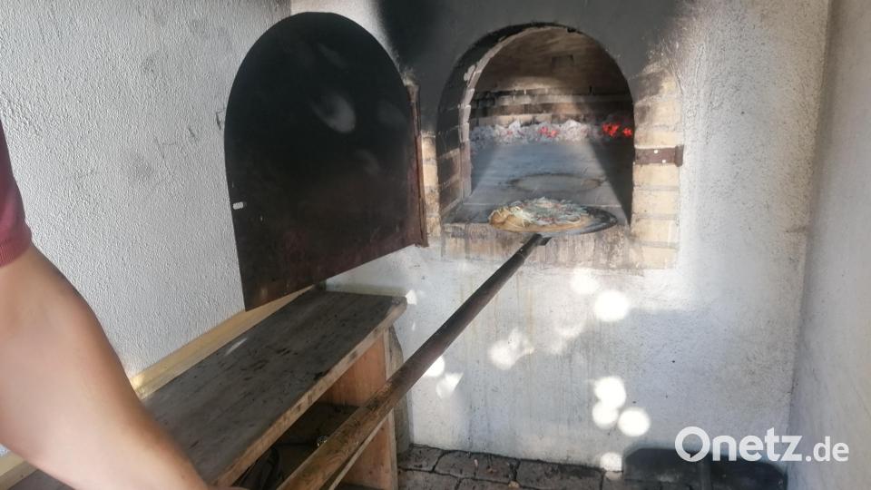 Der erste Zwiebelkuchen wird in den Steinofen geschoben. Der Zwiebelkuchen hat Tradition bei der Feuerwehr Frotzersricht. Bild: kec