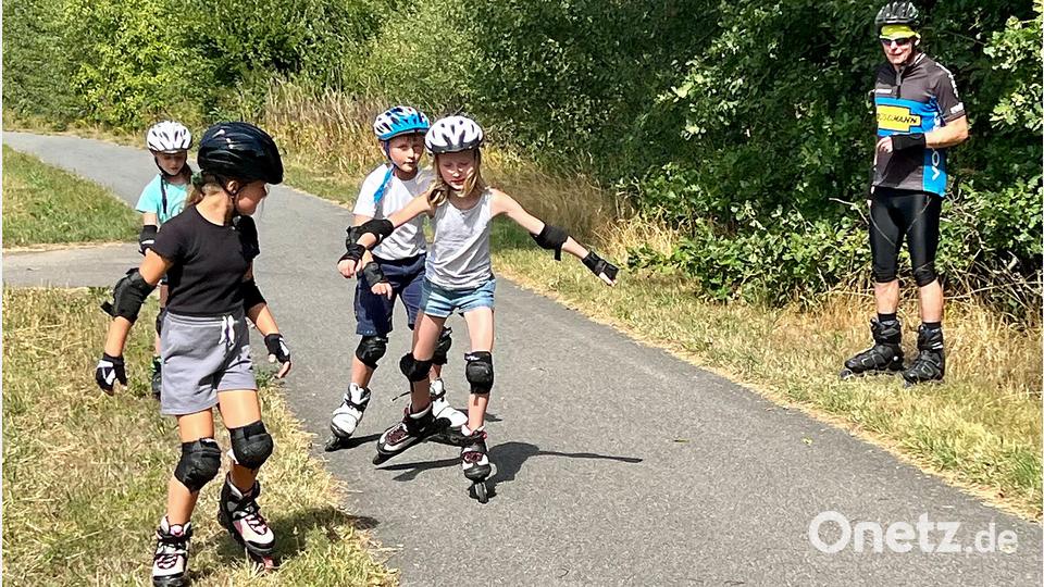 Das spontane Ausweichen auf die Wiese mag geübt sein. Sportler Manuel Jeltsch (rechts) gab den Kindern mehrere Tipps, wie sie sicherer auf den acht Rollen unterwegs sein können. Bild: nza
