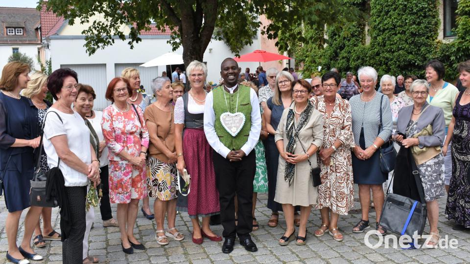 Eine Trachtenweste ist das Geschenk des Frauenbundes für Pfarrvikar Gilbert. zum Ende seiner Urlaubsvertretung Bild: rgr