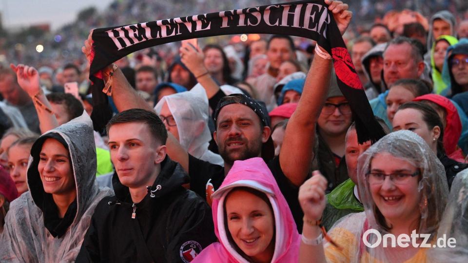 Eine Rekordzahl von 130.000 Fans feierte mit Regenponchos im strömenden Regen. Bild: Angelika Warmuth/dpa