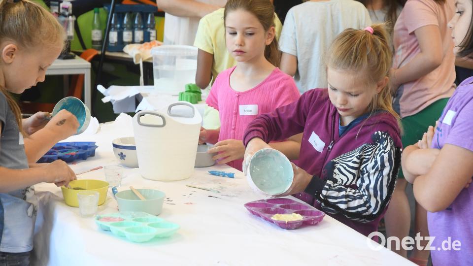 Hier wird fleißig gerührt und experimentiert. Vorsichtig füllen die Kinder die Gipsmasse in die Förmchen. Bild: Gabi Schönberger