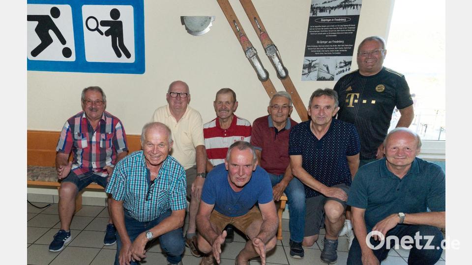 Die ehemaligen Skispringer aus Freudenberg freuen sich, dass die historischen Sprungskier (hinten) im SV-Sportheim einen Ehrenplatz gefunden haben (von links): Martin Koch, Hermann Koch, Hans Gradl, Martin Binner, Alfred Demleitner, Max Straller, Erich Daucher, Berthold Ries und Albert Daucher. Bild: koa