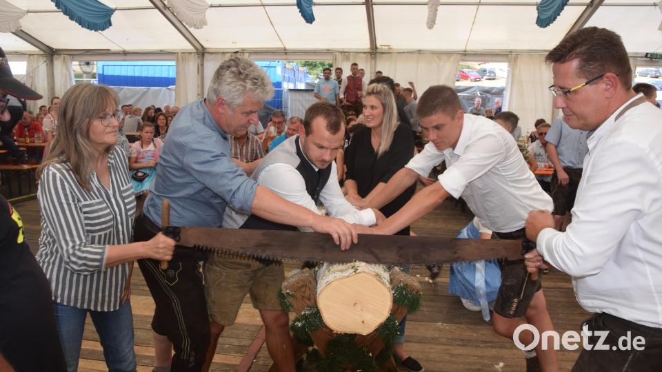 Bürgermeister Robert Lindner (Zweiter von links) justiert die Säge ein. 3400 Gramm sollen vom Stamm gesägt werden. Zweiter Bürgermeister Oliver Mutterer (rechts) gibt zum Sägen den Takt an. Am Ende waren es 3900 Gramm, die Bestwert bedeuteten. Bild: fz