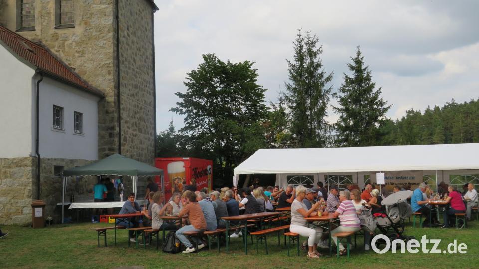 Im Schatten der Kirche feiern. Bild: adj