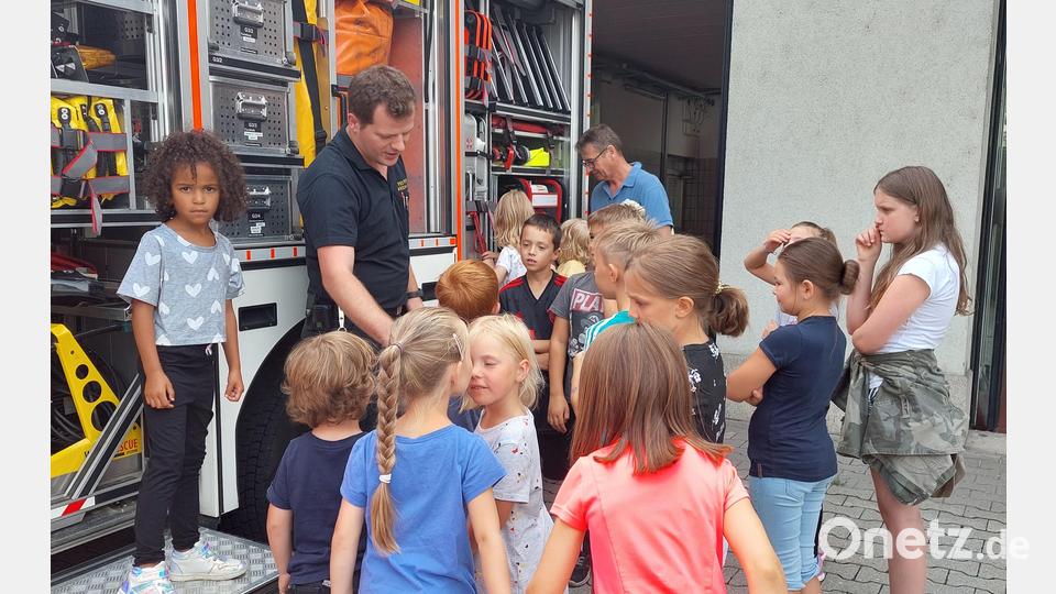 Interessiert hören die Kinder Michael Wirth zu. Er erläutert das Innenleben einen Einsatzfahrzeuges. Bild: Wulfänger/exb