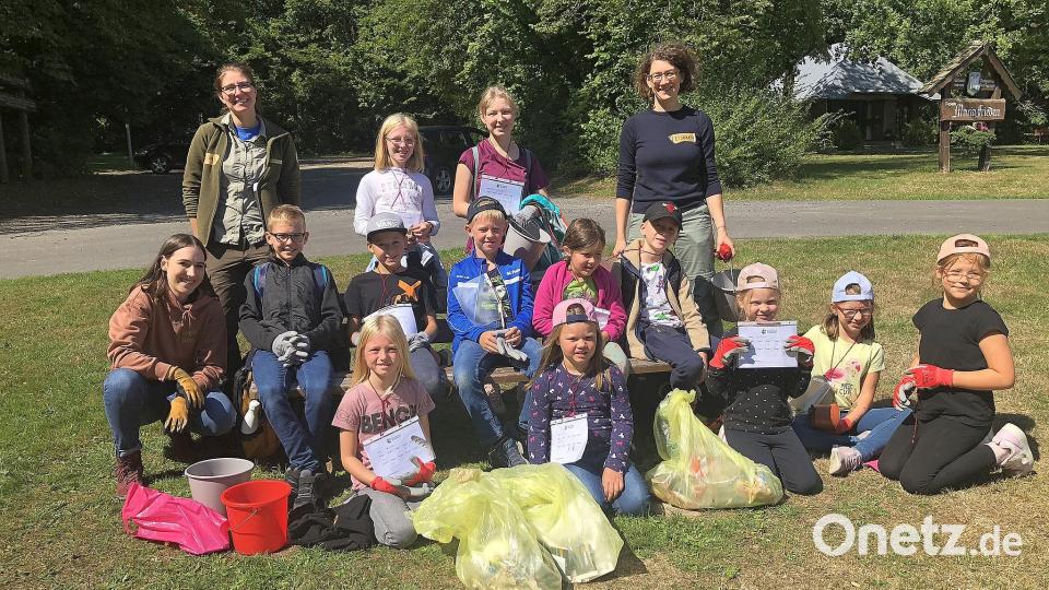 Ein Dutzend KInder, ferner NIna Lang (knieend links), Naturpark-Rangerin Cornelia Greiner (hintere Reihe, links) und die Geschäftsführerin des Naturparks Steinwald, Elisabeth Frank (hintere Reihe rechts), krempelten die Ärmel hoch, um einen Teil des Steinwaldes vom Unrat zu befreien. Bild: wro