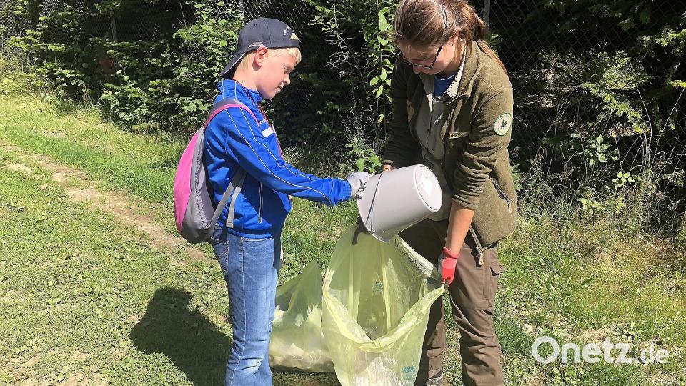 Mit dabei: Naturpark-Rangerin Cornelia Greiner (rechts), die viel Wissenswertes über den Naturpark Steinwald, dessen Tiere und Pflanzen vorbereitet hatte,. um es den Kindern näher zu bringen. In den Mittelpunkt des Samstags rückte das Befüllen von Eimern und Säcken mit dem herumliegenden Unrat. Bild: wro
