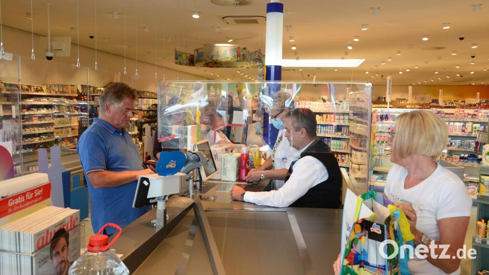 Bürgermeister Andreas Wutzlhofer sitzt im Drogeriemarkt hinter der Plexiglasscheibe an der Kasse. Bild: bey