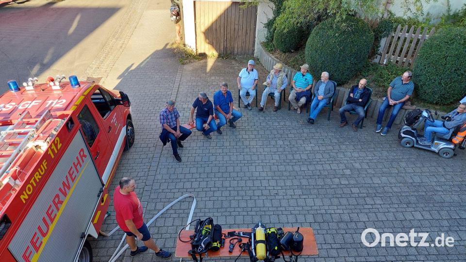 Erster Kommandant Benjamin Weiß (Mitte / links / rechts bzw. rotes Shirt 😊) erklärt die Technik und das korrekte Anlegen der Atemschutzgeräte. Bild: Michael Weiß