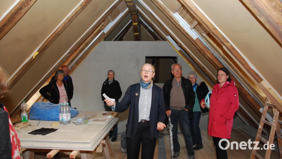 Gertrud Rösch zeigt den Besuchern den denkmalgeschützten Dachstuhl, der erhalten werden kann. Bild: gsp