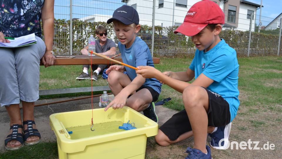 Die Brüder Fabian und Julian geben sich gegenseitig Tipps, wie man am besten die Fische aus dem Wasser zieht. Bild: kki