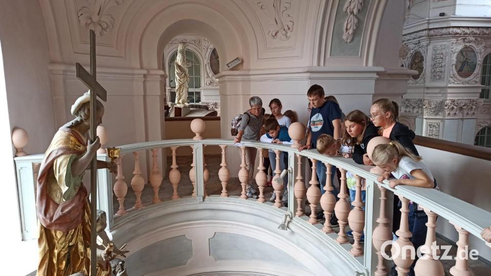 Ein Teil der Kinder mit Monika Mittereder (links) , die beim Rundgang durch die Basilika einen interessanten Blick von oben zu den Seitenaltären wagen durften. Bild: Doris Zabiegly/Andrea Wührl/exb