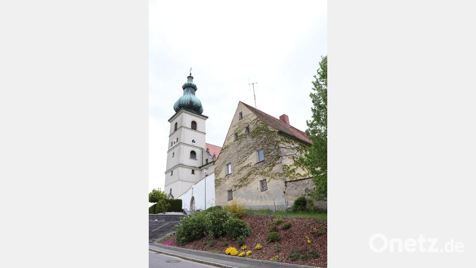 Ortsprägend steht das Kooperatorhaus (rechts) direkt neben der katholischen Kirche Mariä Himmelfahrt in Beidl. Dazwischen liegt der Friedhof der kath. Kirche. Bild: flt