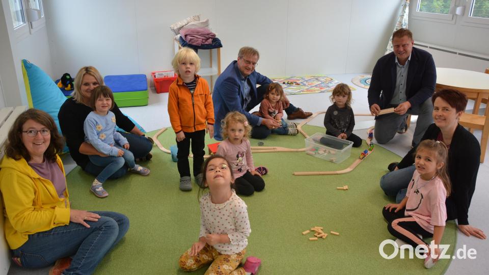 Kinderhausleiterin Julia Merz-Neudert (links) und ihr Team, die betreuten Kinder, Lebenshilfe-Geschäftsführer Berthold Kellner (Mitte) und Bürgermeister Stefan Grillmeier (hinten) sind zufrieden mit dem Betrieb im Container-Kinderhaus. Bild: jr