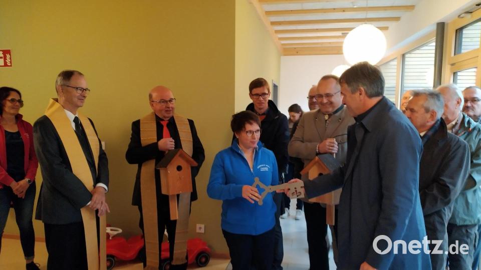 Pfarrer Martin Neumaier, Pfarrer Wilhelm Bauer, Kinderhausleiterin Manuela Hinkel, Landschaftsarchitekt Korbinian Schönberger, Bürgermeister Ludwig Gürtler, Architekt Christian Schönberger und Kirchenpfleger Hans Maier (von links) bei der symbolischen Schlüsselübergabe. Bild: rfi