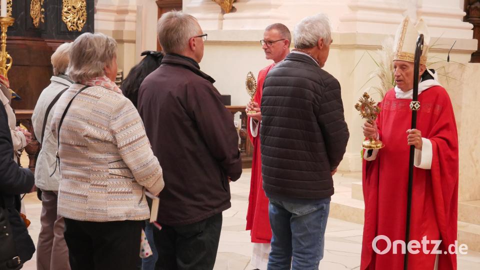 Nach dem Gottesdienst ließen sich zahlreiche Gläubige von Abtpräses em. Dr. Notker Wolf OSB (rechts) und von Stadtpfarrer Dr. Thomas Vogl mit dem Kreuzreliquiar und der Zusage „Im Kreuz ist Heil, im Kreuz ist Leben, im Kreuz ist Hoffnung“ einzeln segnen. Bild: hmr