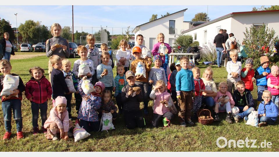 Lukas (in der Mitte mit Kappi) , der frisch gekrönte Kartoffelkönig, präsentiert stolz seinen Fund mit einem Gewicht von 393 Gramm. Bild: mfh