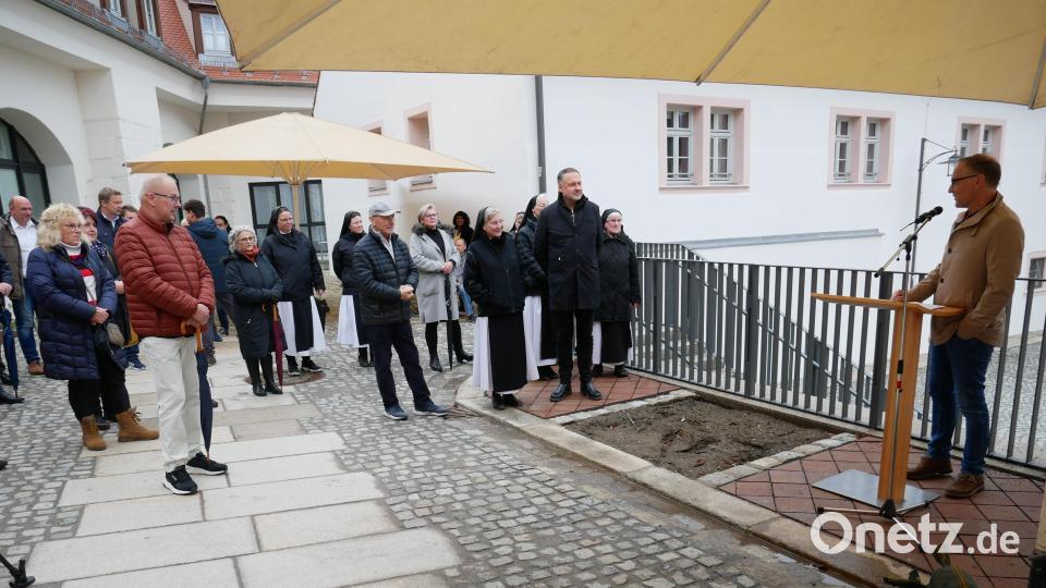 Bürgermeister Bernd Sommer (rechts) zusammen mit dem Klosterkonvent, Anwohnern und Vertretern der beteiligten Firmen sowie Gästen bei der Einweihung des Cäcilienplatzes im Mühlbachviertel. Bild: hmr