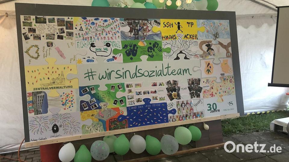 Auf seiner Abschlusstour &quot;30 Jahre Sozialteam&quot; machte das große Firmenpuzzle auch in Fuchsmühl Station, wo es mit dem noch fehlenden Stück aus dem Senioren-Servicehaus vervollständigt wurde. Bild: wro