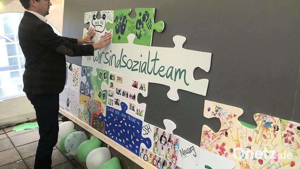 Geschäftsführer Christian Weiß setzte die einzelnen Puzzleteile (als Symbol der vielen Einrichtungen) zusammen. Auf der noch verborgenen Rückseite war das neue Firmenlogo aufgedruckt. Bild: wro