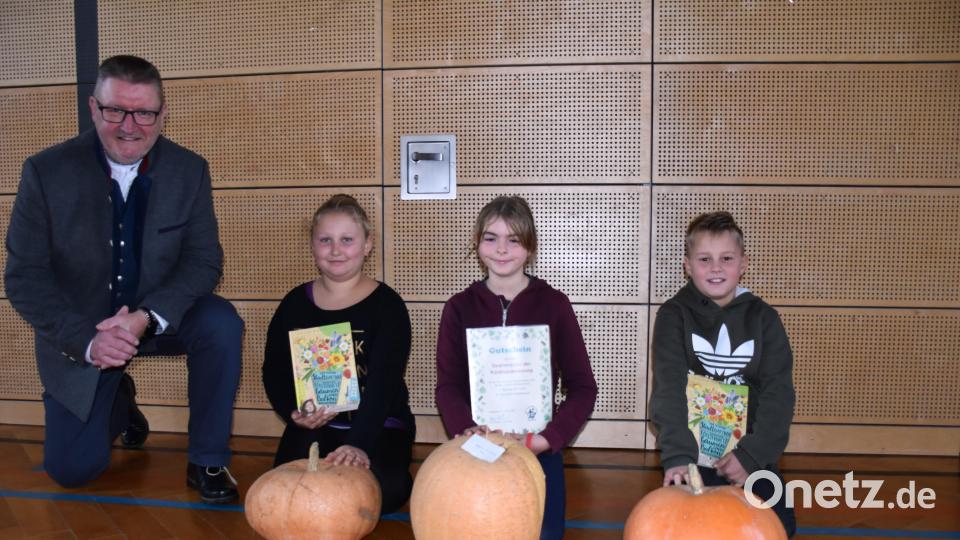 Klaus Schuster (von links) zeichnete die Kinder mit den prächtigsten Kürbissen aus – Leonie Prüfer (8,6 Kilo, 3. Platz), Sophie Hubrich (10,6 Kilo, 1. Platz) und Hugo Männer (9,7 Kilo, 2. Platz). Bild: ubb