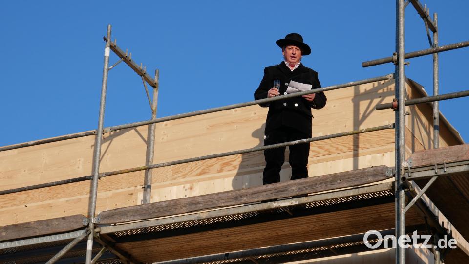 Vom höchsten Punkt des Kinderhauses verkündete Zimmerermeister und Seniorchef Andreas Altmann seinen Richtspruch und ließ das Sektglas anschließend traditionsgemäß zu Bruch gehen. Bild: hmr