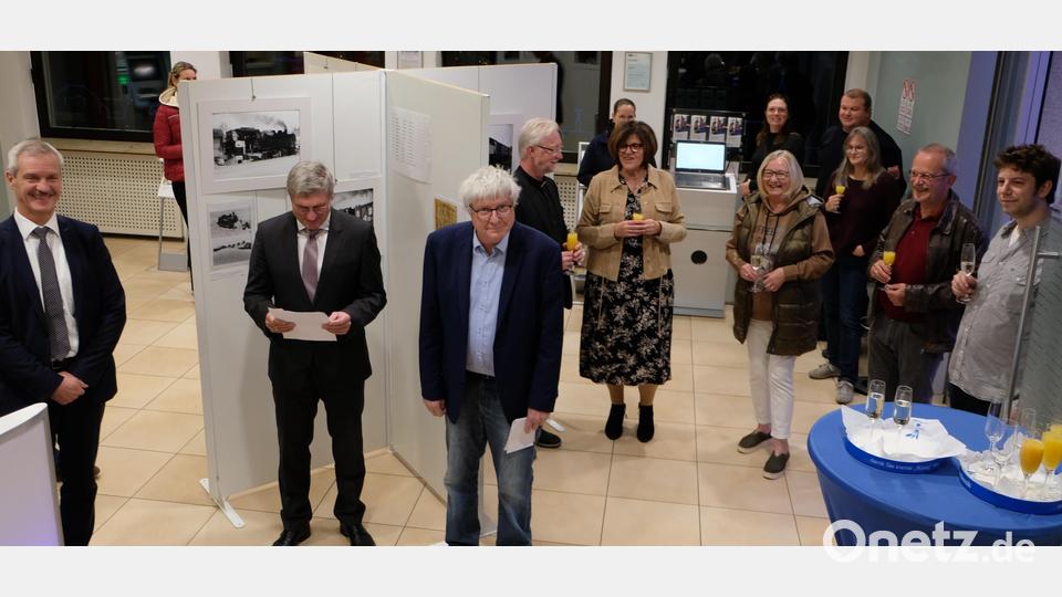 Einem illustren Besucher- und Gästekreis erläuterte Martin Müller ( stehend Dritter von links ) in der Vernissage am vergangenen Donnerstag in den Räumen der Raiffeisenbank die Technik der Dampfloks. Bild: le
