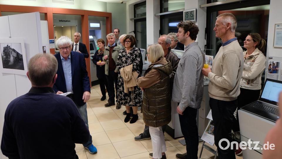 Martin Müller (Brille) gibt bei der Vernissage einen Einblick in sein umfangreiches Wissen über Dampfloks. Bild: le