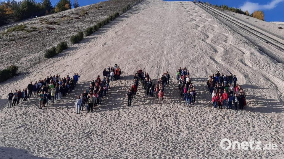Zum Abschluss bildeten die Teilnehmer das Wort Minis am Fuße des Sandberges. Bild: fdl