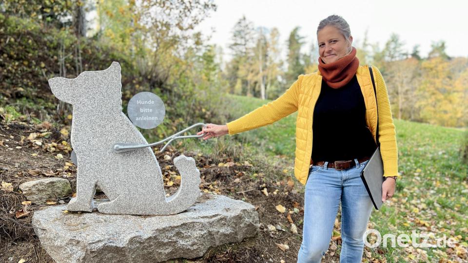 Katrin Hartisch zeigt, wie man mit dem „Weg des Granits“ interagiert: Einmal den Granit-Hund an der Leine ziehen und es erscheint der Hinweis „Hunde bitte anleinen“. Das ist besonders wichtig wegen der Schafe, die rund um den Schlossberg ihre wichtige Mäharbeit verrichten. Bild: Eichl
