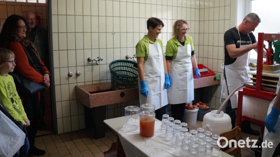 Die Zuschauer beim Apfelsaftpressen freuen sich auf eine Kostprobe. Bild: wel