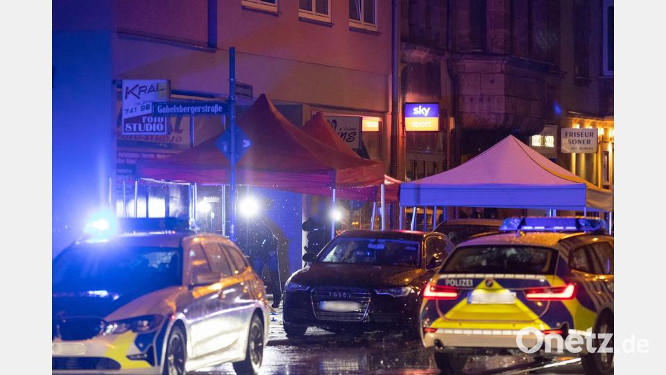 Polizisten stehen neben einer Straßenbahn in der nähe eines Tatorts, nachdem hier Schüsse gefallen waren. Bild: Daniel Karmann