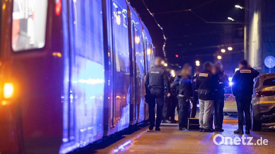 Polizisten stehen neben einer Straßenbahn in der nähe eines Tatorts, nachdem hier Schüsse gefallen waren. Bei Schüssen in der Nürnberger Südstadt ist am Abend ein Mann ums Leben gekommen, ein weiterer wurde schwer verletzt. Bild: Daniel Karmann