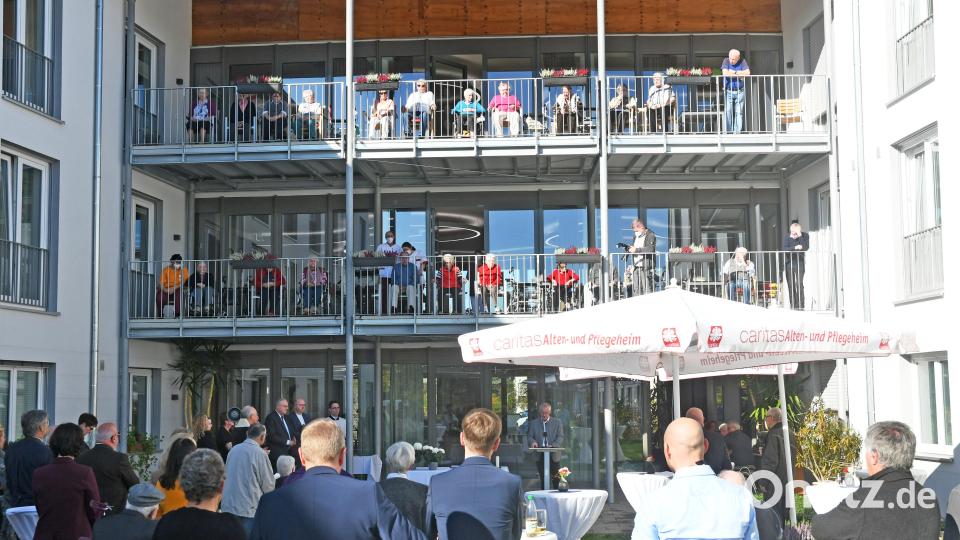 Gäste und zahlreiche Heimbewohner auf den Balkonen wohnen der Segnung des Caritas Wohn-, Pflege- und Sozialzentrums St. Konrad bei. Bild: Gabi Schönberger