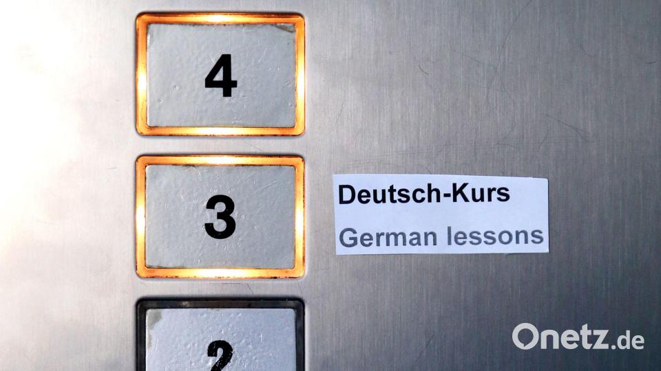 Ein Schild „Deutsch-Kurs“ und „German lessons“ klebt im Fahrstuhl eines Bürogebäudes. Symbolbild: Jan Woitas/dpa