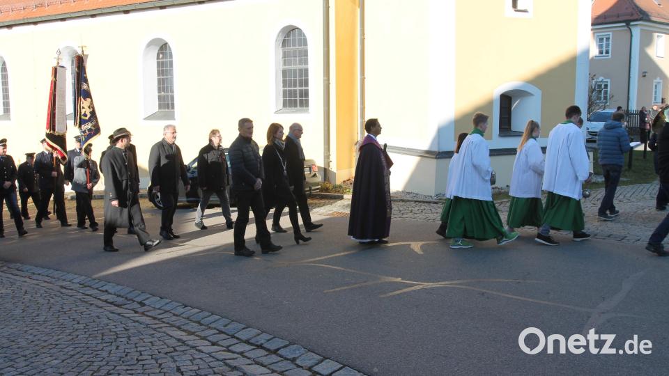 Mit Pfarrer John Subash und Bürgermeisterin Marina Hirnet (mit Amtskette) ziehen die Vereine und Verbände zur Totenehrung am Kriegerdenkmal. Bild: pi