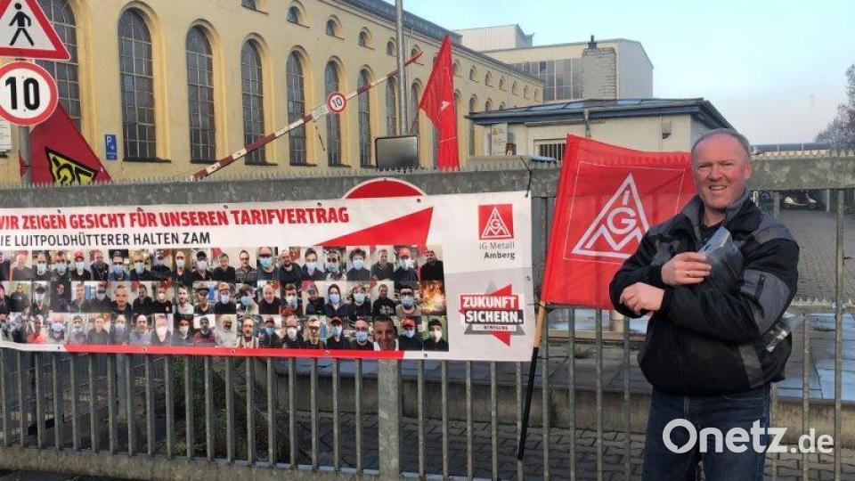 Warnstreik bei der Luitpoldhütte: Die Schranke ist unten und sie ziert ein Banner mit den Portraits vieler Mitarbeiter, die mit der IG Metall an ihrer Seite um eine Tariferhöhung kämpfen. Bild: IG Metall Amberg
