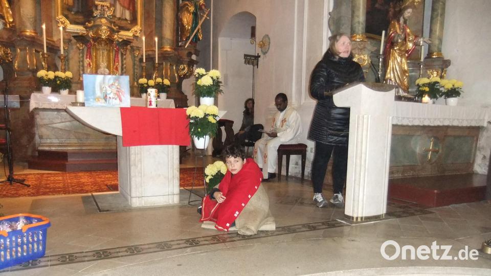 Der in der Nikolauskirche knieende und frierende Bettler hatte im Spiel soeben vom mitmenschlichen Heiligen Martin die Hälfte von seinem roten Mantel erhalten. Ein Lichtblick für den armen Mann in kalter Nacht. Bild: gm