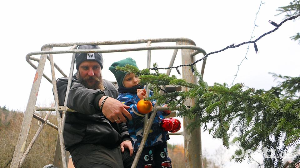 Hoch im Kurs stand vor allem bei Kindern das Anbringen der Christbaumkugeln. Sandro Jahn (links) beförderte die schwindelfreien Mädchen und Jungen in der sicheren Hebebühne oft bis zur Baumspitze. Bild: bsc