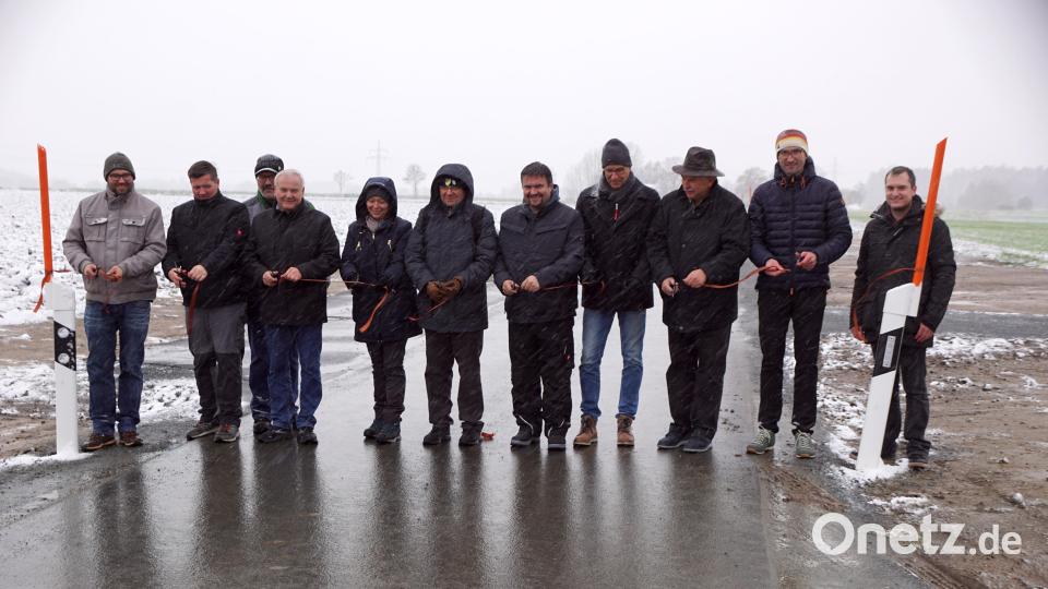 Das Band ist durchschnitten. Bürgermeister Günter Kopp (Vierer von links), Pfarrer Markus Bruckner (Sechster von links) und Diplom-Ingenieur Christoph Reger (Zweiter von rechts) griffen zur Schere. Bild: bkr
