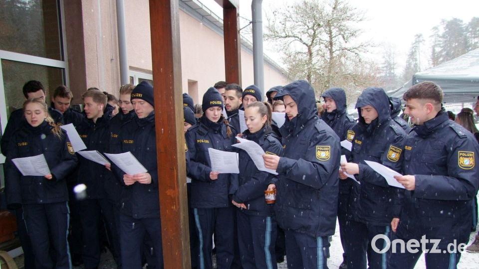 Studierende greifen zum Liedblatt und leisten einen musikalischen Beitrag zum Wintergrillen. Bild: Thomas Scheuring/exb